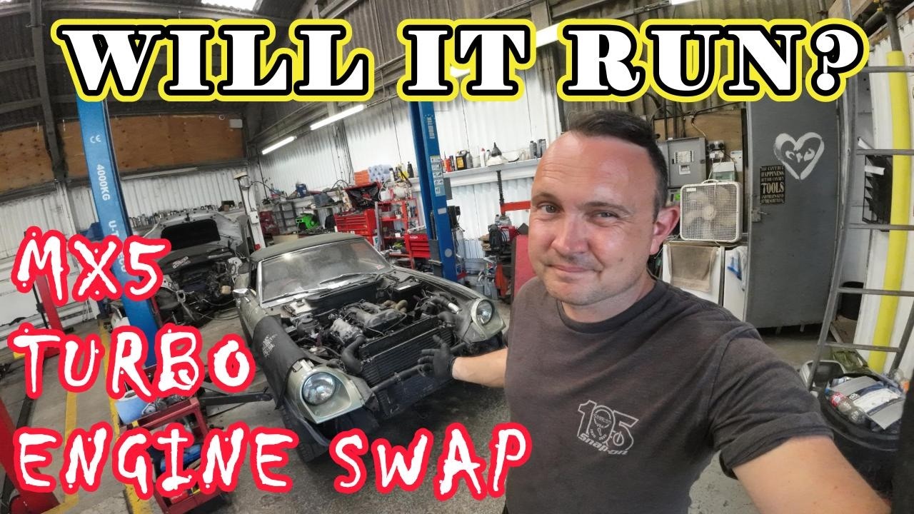Lewis and Dan diagnosing the Mazda MX-5 engine swapped into a classic Jensen Healey in their workshop.