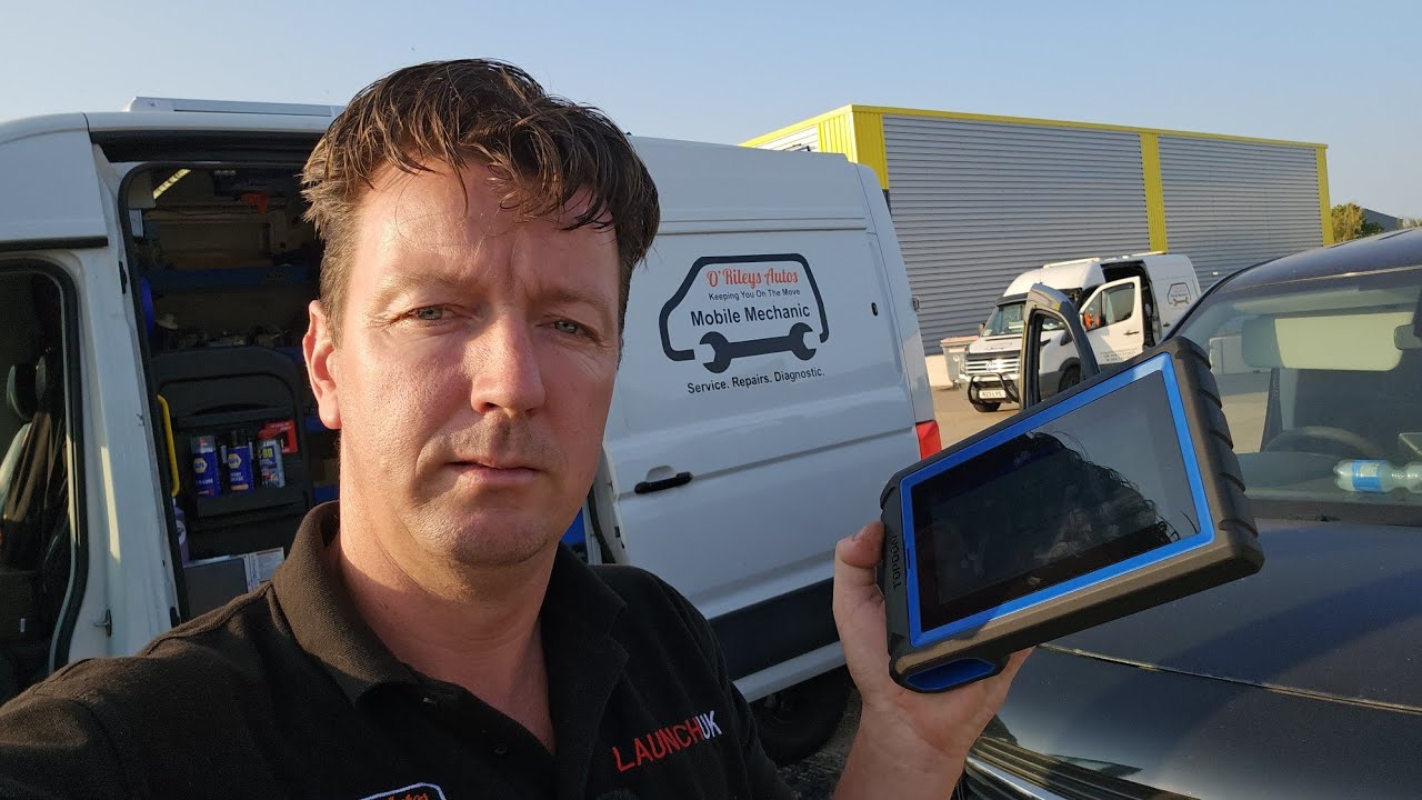 Technician uses a TOPDON scan tool to diagnose an engine fault on a modern Vauxhall Combo van in a workshop.