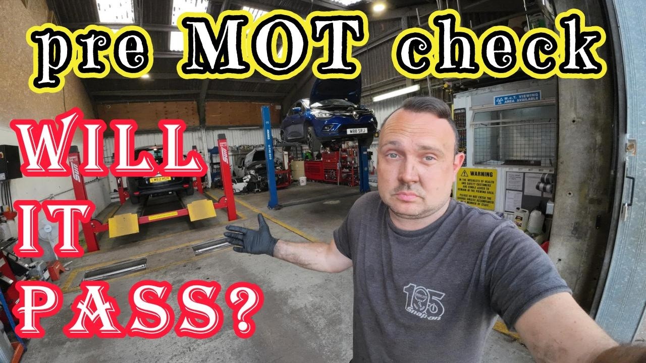 Mechanic inspecting a car on a workshop ramp during an MOT pre-check to identify common MOT failures.