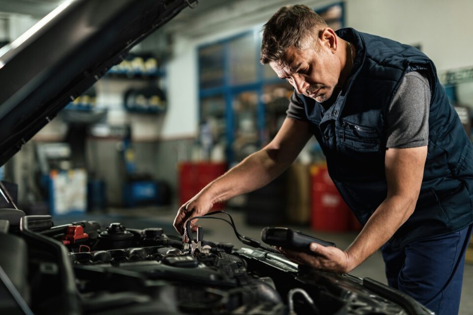 A mobile mechanic working on a car during the busy MOT period, highlighting opportunities for technicians without their own