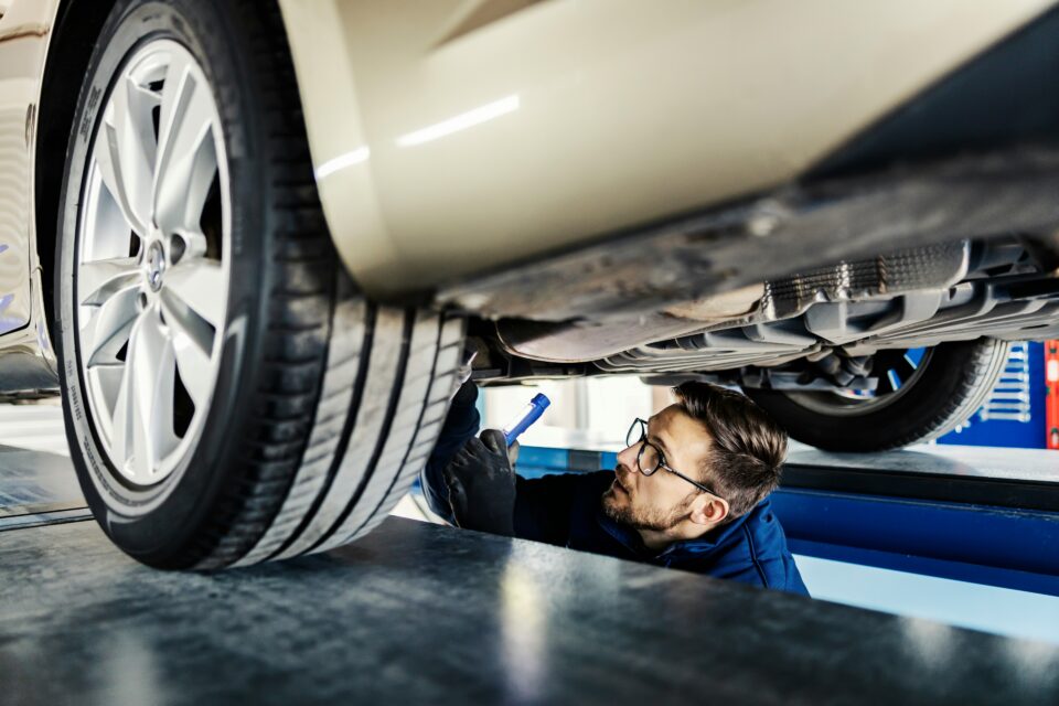 A technician explaining a repair to one of many UK drivers who feel anxious, building trust in a modern workshop setting.
