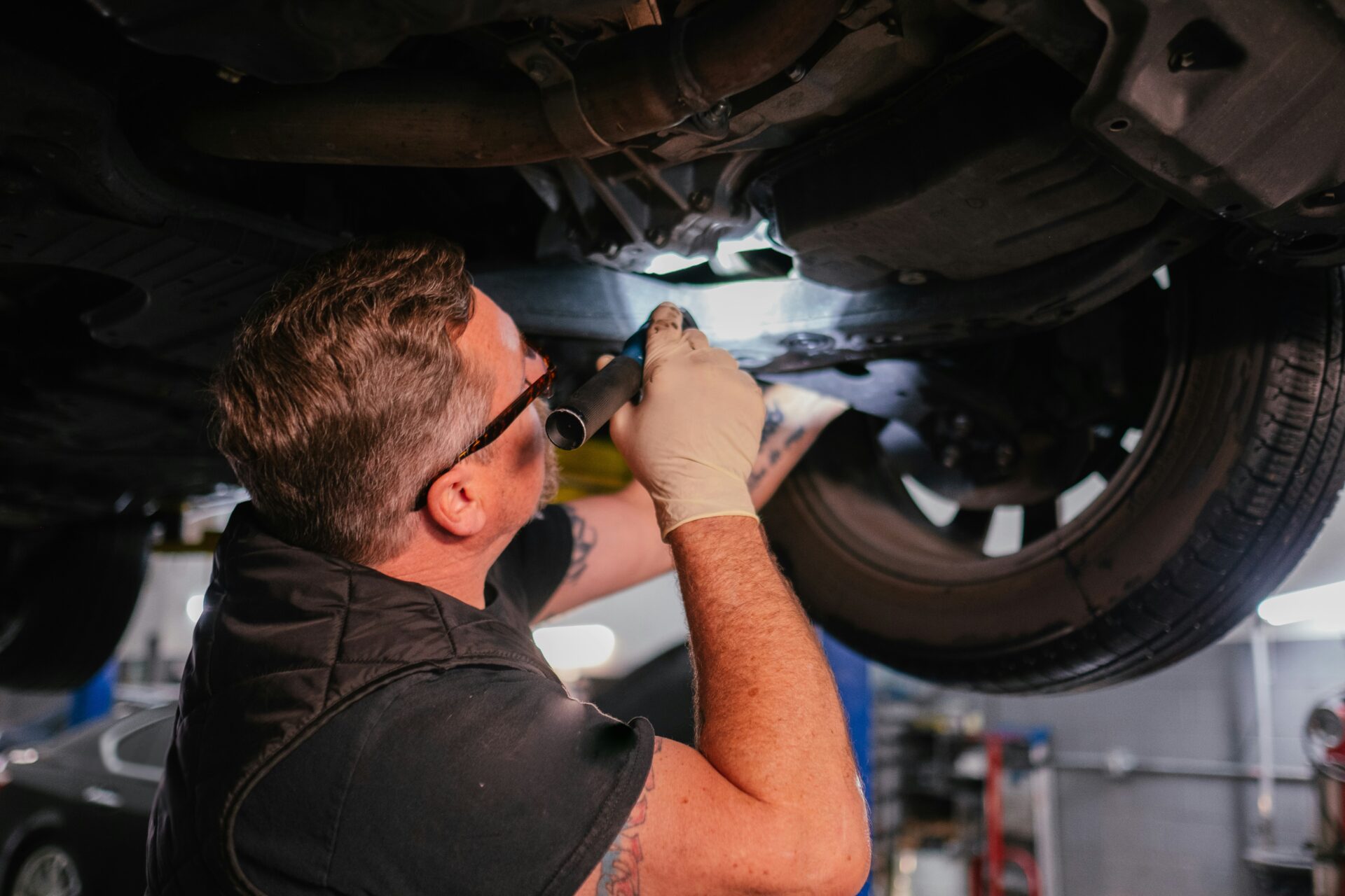 An MOT tester uses a smartphone to take a picture of a car during the DVSA's new Photos at Test process in a workshop bay.