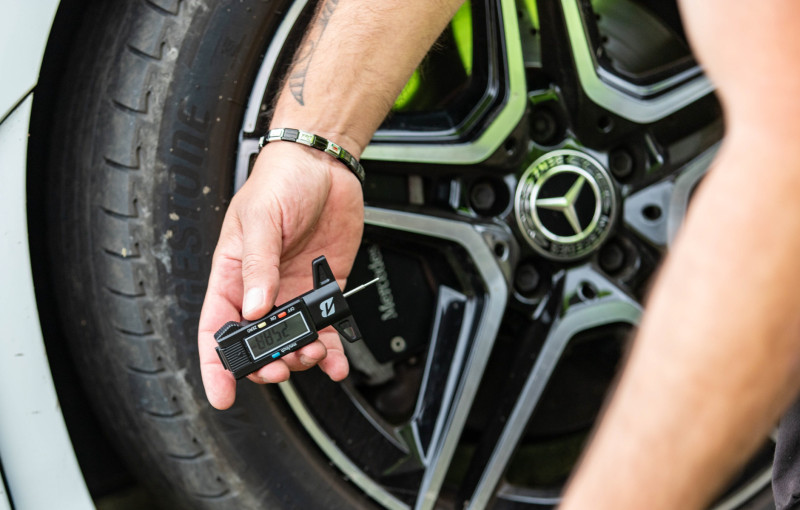 A technician points to the worn tread on a vehicle's wheel, highlighting the danger of defective tyres on Britain's roads.