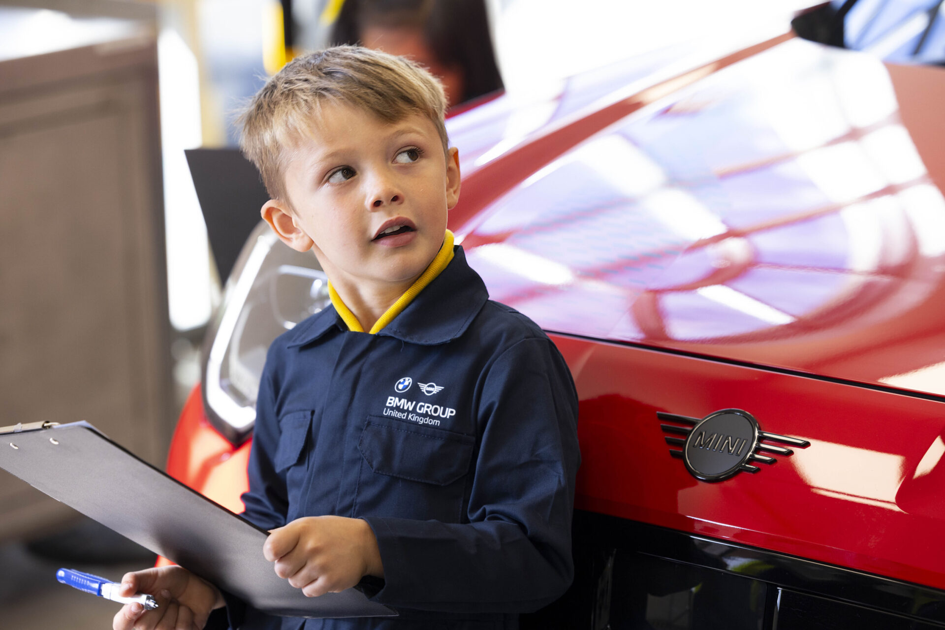 Young children learning about electric vehicle parts as part of a new strategy for recruiting apprentices for UK workshops.